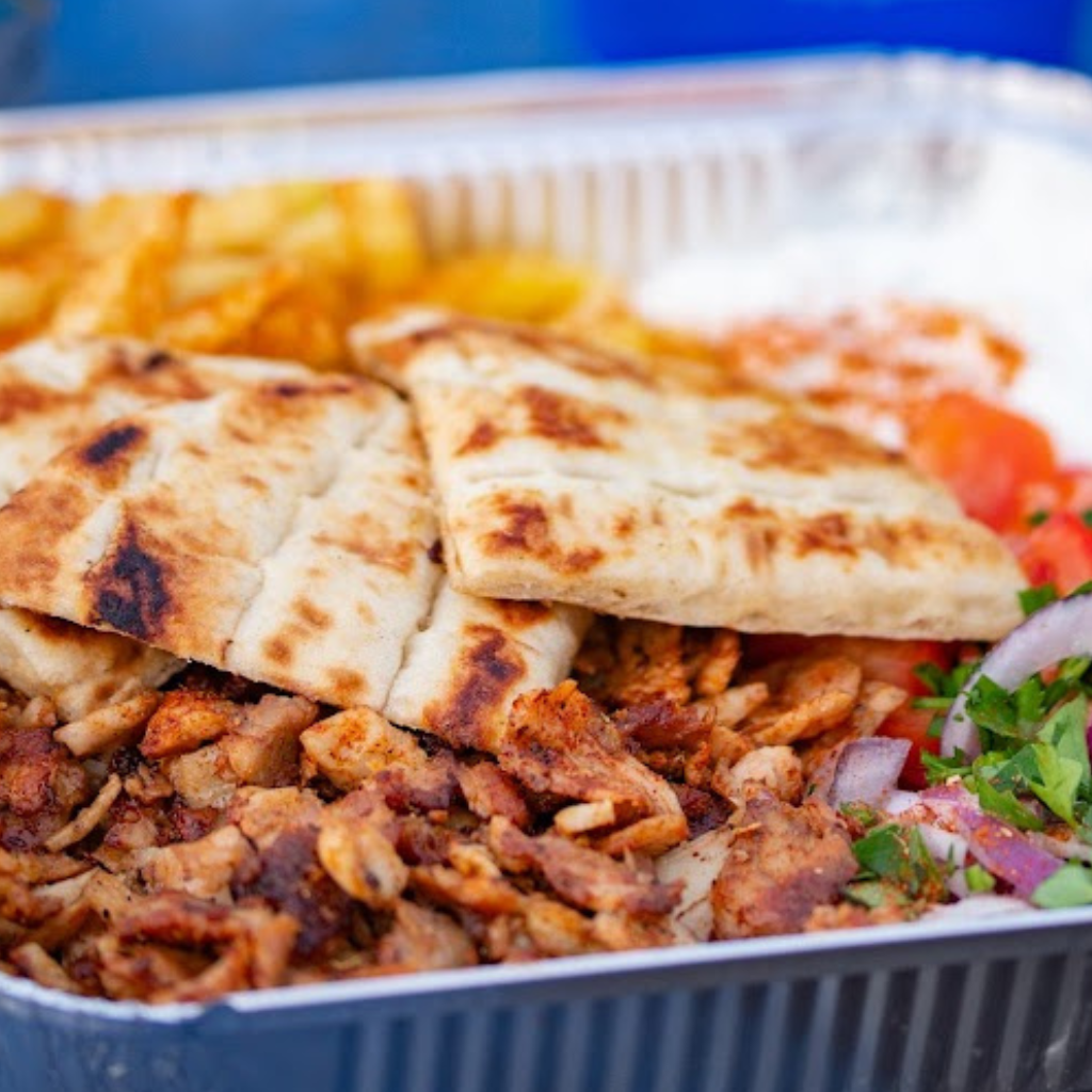 Chicken gyros plate served with chips, salad, pita bread and homemade tzatziki at MacTassos.